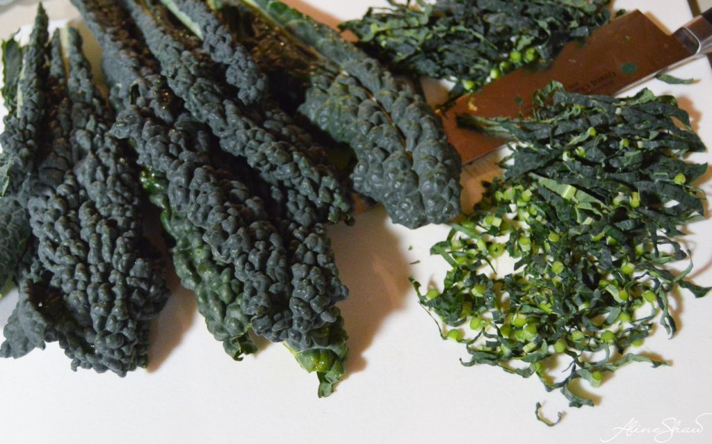 kale leaves on a cutting board before and after slicing thinly