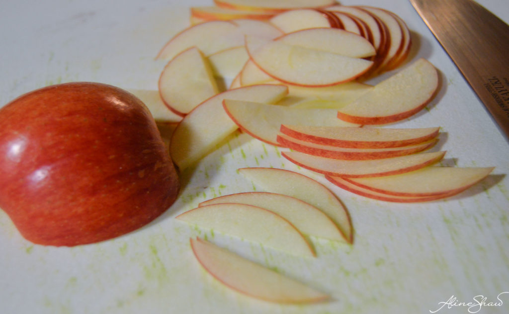 thinly sliced apple on a cutting board