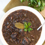 Close up of a white bowl holding a serving of Brazilian black beans