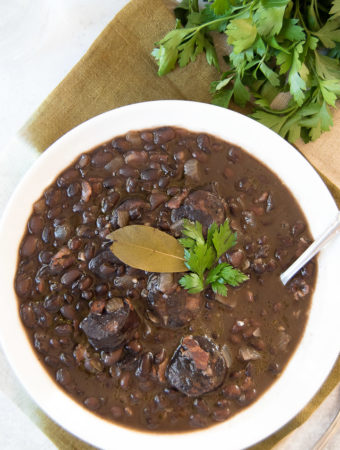 Close up of a white bowl holding a serving of Brazilian black beans