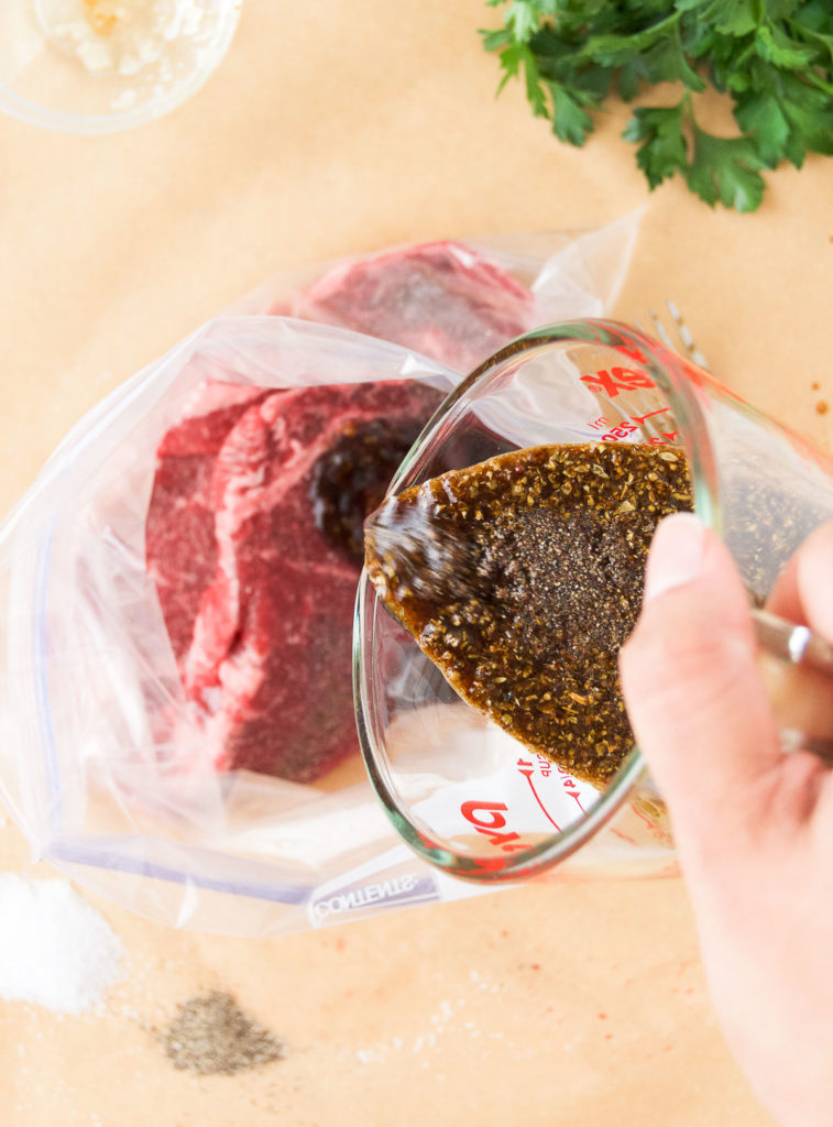 Marinade pours over steaks in a plastic bag