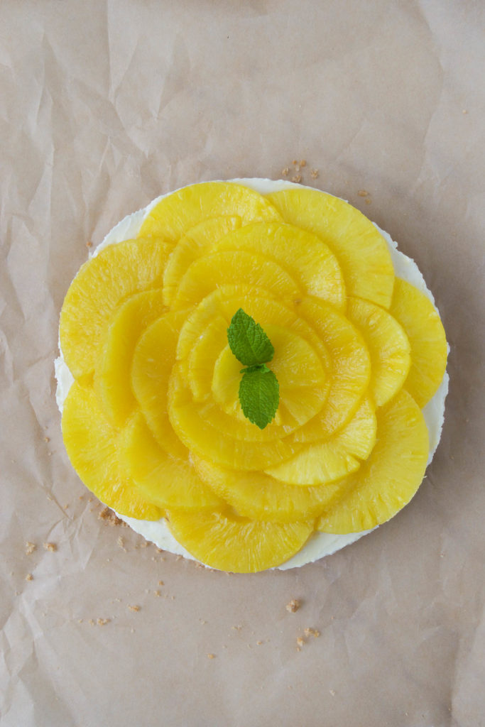 A no bake pineapple cheesecake with mint leaves. 