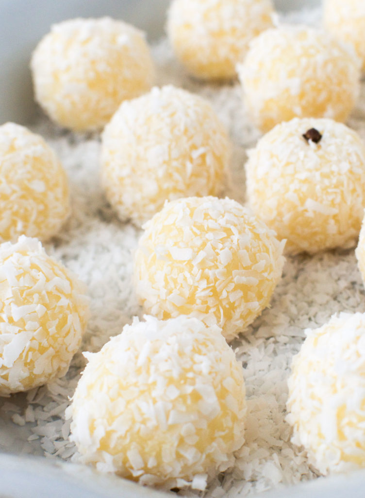 Close up of Brazilian coconut balls on a platter and garnished with whole cloves 
