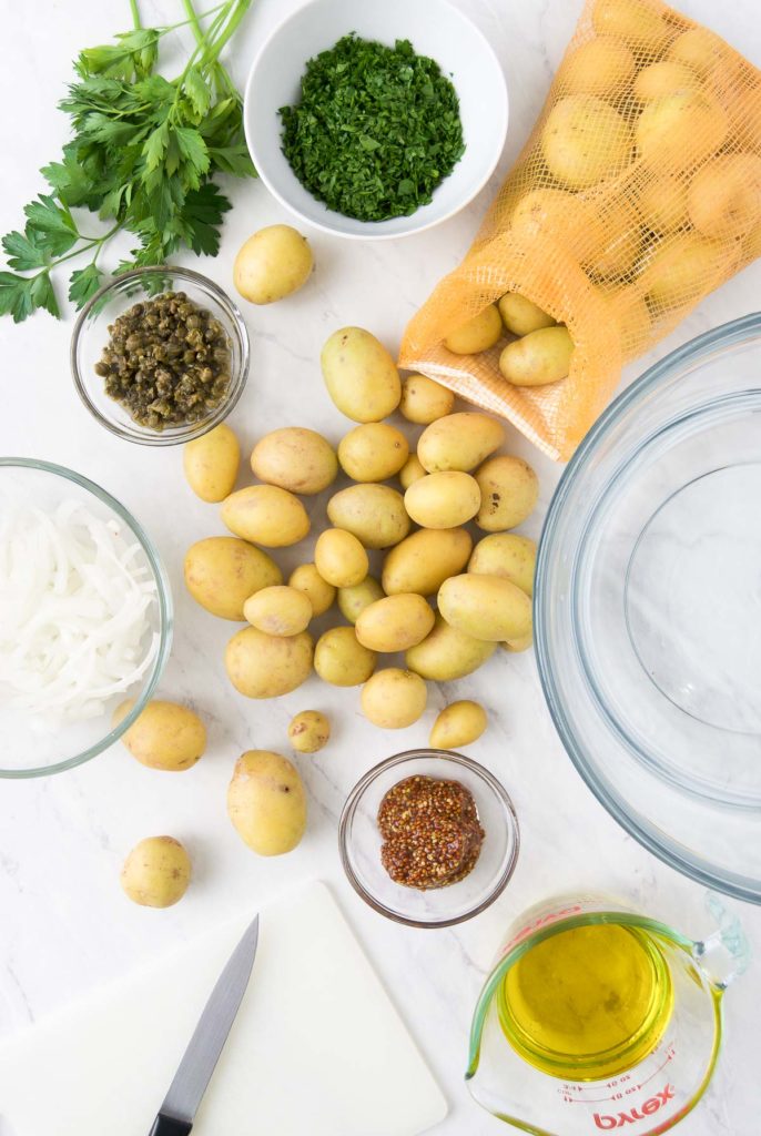 Gold potatoes with other vegan potato salad ingredients on a countertop