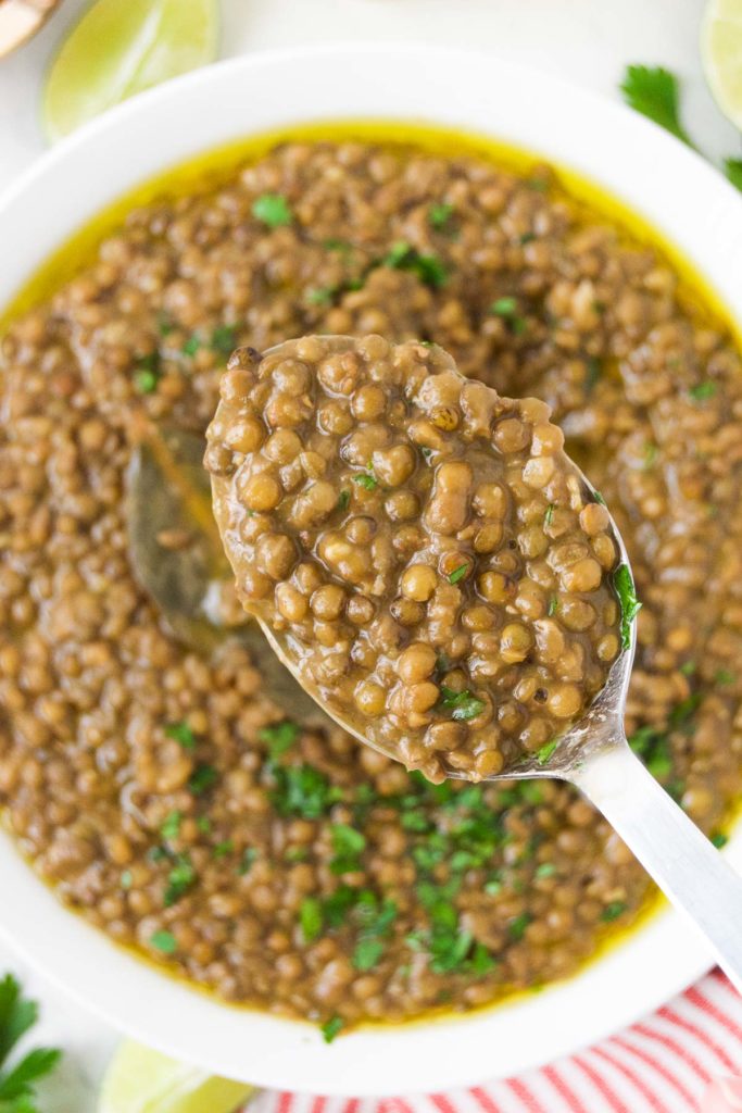 A spoon holds a scoop of Instant Pot lentils