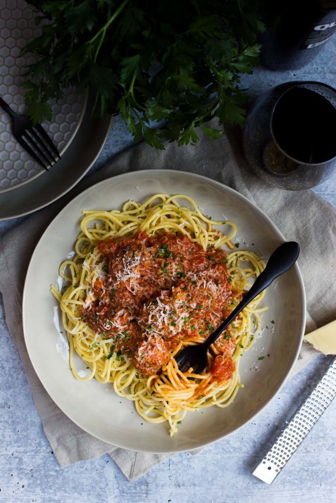 Spaghetti and meatballs in a white plate with a form