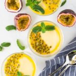 Two small containers of passion fruit mousse with mint and seed garnishes