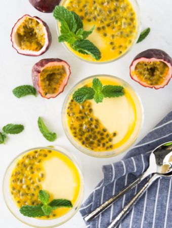Two small containers of passion fruit mousse with mint and seed garnishes