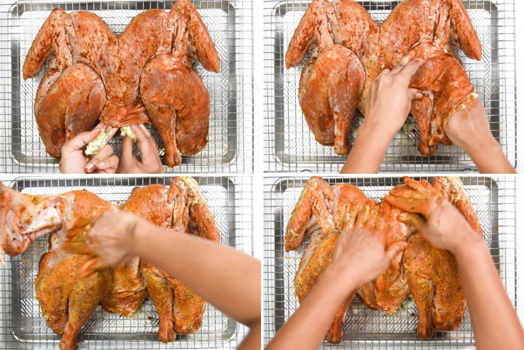 A person rubs compound butter on a spatchcock turkey