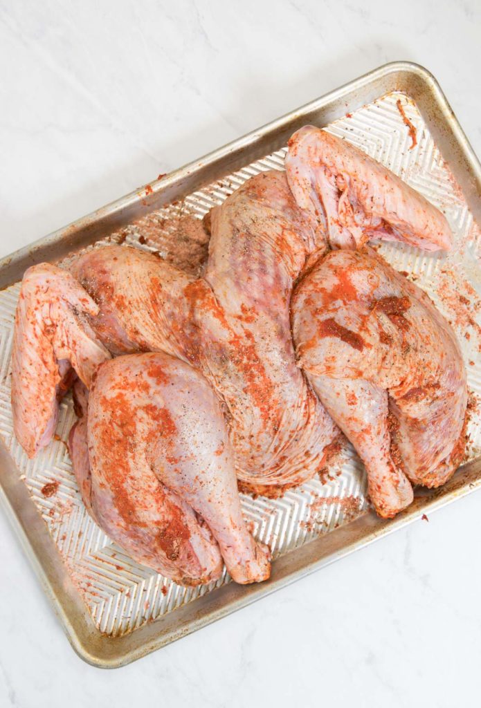 A spatchcock turkey with dry brine all over it
