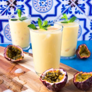 Three passion fruit drinks on wood with mint garnishes