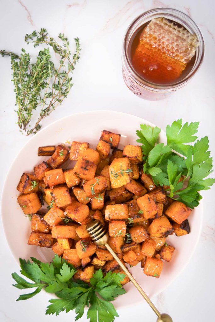 A bowl of air fryer butternut squash with herbs and honey