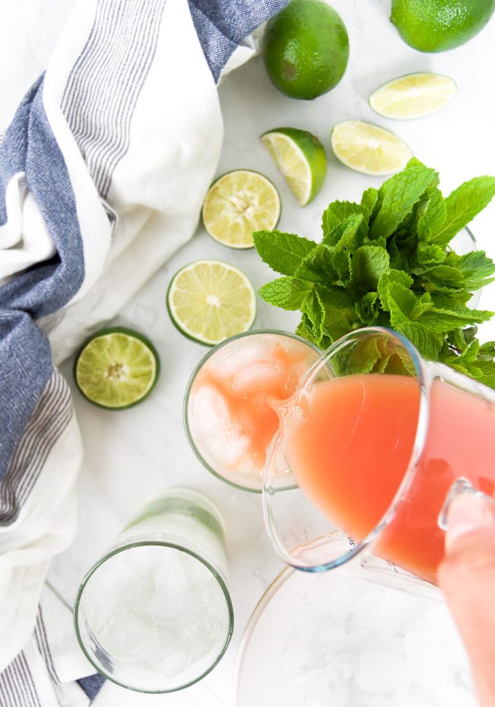 Guava nectar is poured over mojito ingredients in a large glass