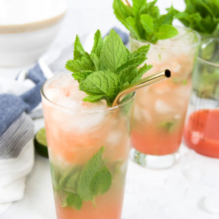 Two Guava Rum Cocktails garnished with mint and surrounded by ice