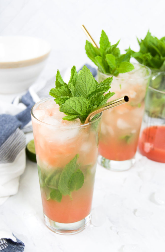 Two Guava Rum Cocktails garnished with mint and surrounded by ice