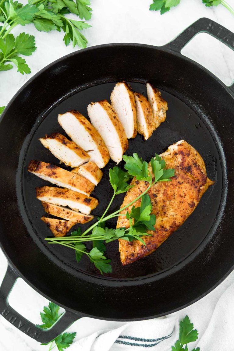 Seared chicken in a skillet with parsley