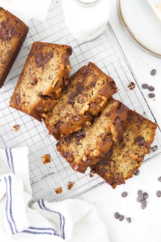 Slices of chocolate chip banana bread with walnuts on a cooling rack
