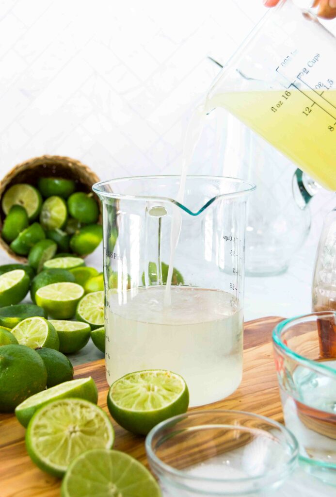 Margarita ingredients pour into a large glass pitcher