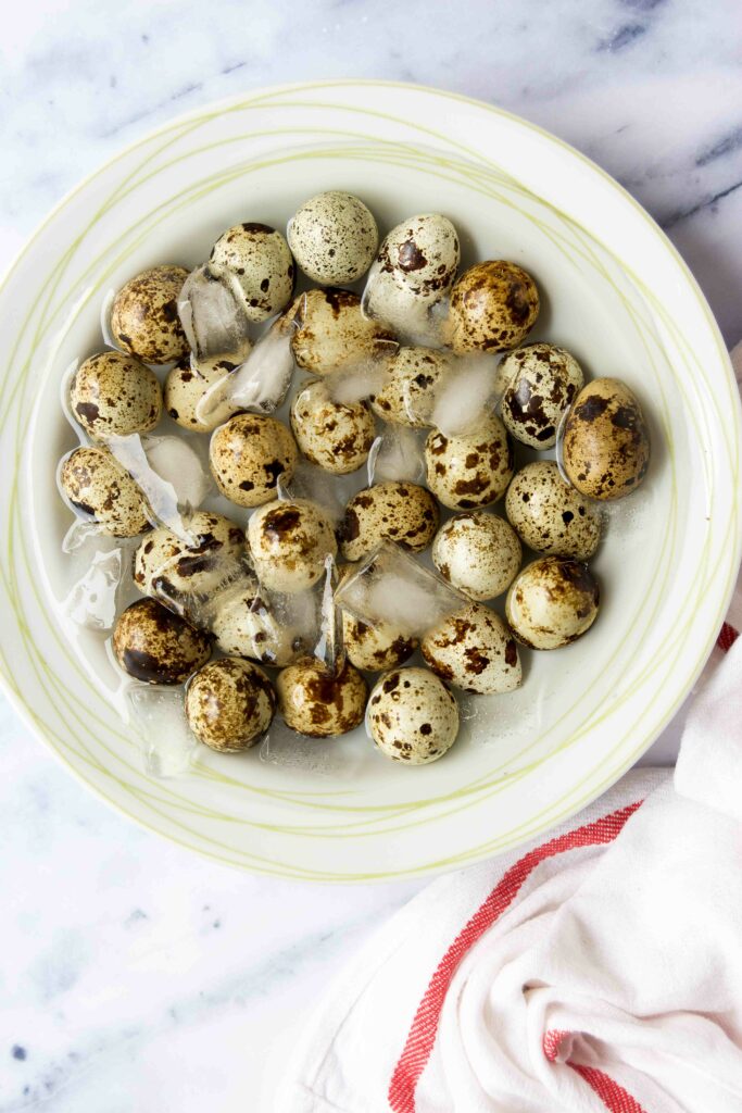 Quail eggs in an ice bath in a bowl after boiling